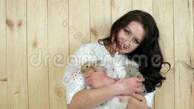 快乐的女孩抱着兔子，保护动物，年轻的女人喜欢小的家兔